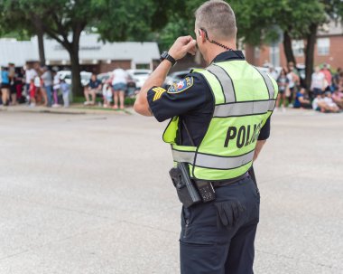 4 Temmuz 'da Dallas, Teksas, Amerika yakınlarındaki resmi geçit töreninde yan görüş polisi. Festivalde kolluk kuvvetleri ve güvenlik görevlisi.