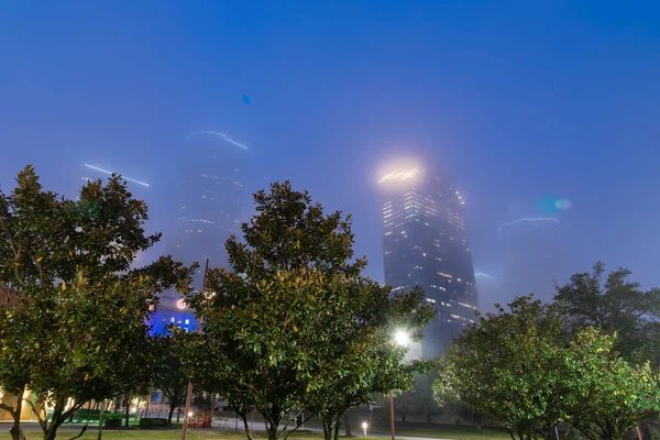 Arranha-céus e arranha-céus edifícios corporativos no centro de Houston em nevoeiro tempo na hora azul — Fotografia de Stock