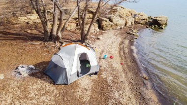 Hava manzaralı büyük aile çadırı ve çocuklar Grapevine Gölü, Teksas, Amerika boyunca kayalık kıyı şeridi yakınında kum oyuncakları. Lakeside kamp kurup kamp ateşi yaktı. Kışın doğal balık avlama alanında.