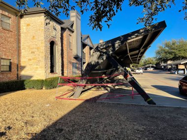 Diğerleri Dallas, Teksas, ABD 'nin banliyölerinde dururken bir apartman garajı düştü. Kırık çelik yapısı ticari park sistemleri, şiddetli hava koşulları ve sarı barikat bantları ile kaplı.
