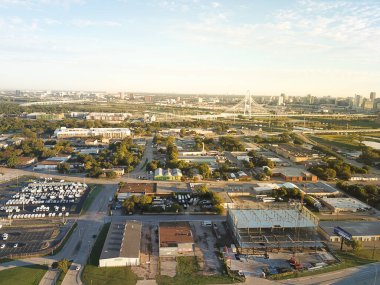 Margaret Hunt Hill Köprüsü 'nün arka planında, Dallas' ın batısındaki Top View iş parkı ve sanayi bölgesi. Açık hava otoparkları olan deniz kabuğu sanayi binası.