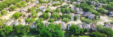 Panorama view an established neighborhood with matured trees and two story houses in Flower Mound, Texas. Upscale parkside Dallas suburbs single family homes large backyard lush green