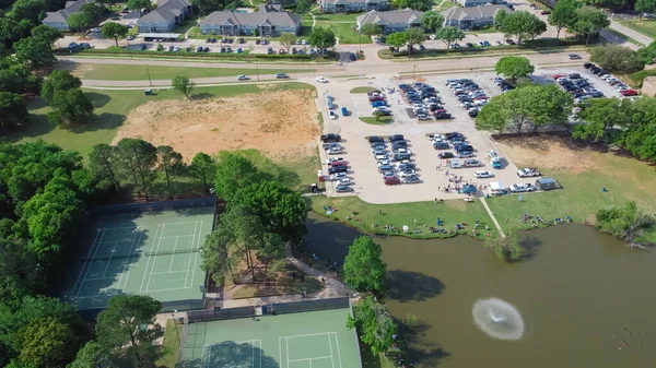在美国得克萨斯州花圃公寓楼建筑群附近的社区池塘里 空中观看一个有网球场的钓鱼活动 城市设施被茂密的绿树和草地环绕 — 图库照片