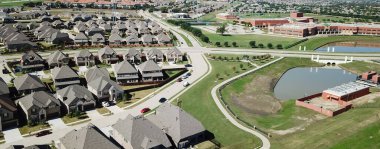 Panorama hava manzaralı yerleşim mahalli, Irving, Teksas 'taki çim parkı ve ilkokul bölgesi yakınlarında. Yeni bir gelişme. Arka bahçesi ve patika sistemi olan iki katlı evler.