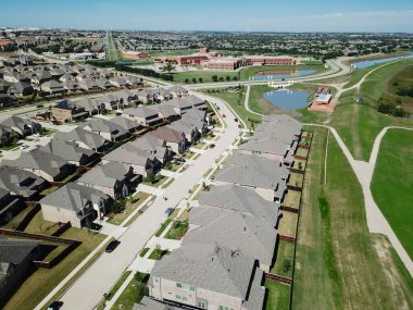 Dallas, Teksas, Amerika 'nın arka planında arka bahçesi ve okul bölgesi olan yepyeni evlerin çatısı. Park yolunun yanındaki iki katlı evler.