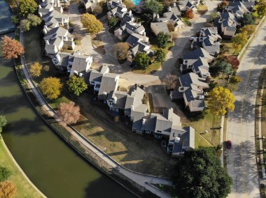 Kuzey Teksas, Amerika 'da renkli sonbahar yeşillikleri olan kanalın yanındaki kasaba evleri. Sonbahar mevsiminde küçük arka bahçesi ve yüzme havuzu olan birbirine bağlı evler.