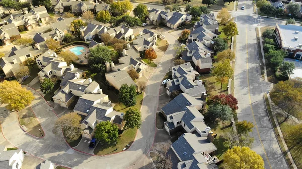 Panorama, Kuzey Teksas, ABD 'de parlak sonbahar yeşillikleri olan büyük bir apartman kompleksinin yanında yüzme havuzu olan yoğun iki katlı kasaba evi görüyor. Küçük arka bahçesi olan yerleşim evleri.