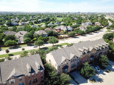 Kuzey Teksas, Amerika 'da golf sahası olan tek bir aile mahallesinin yanında garajı olan yepyeni üç katlı kasaba evleri. Gündüz vakti Dallas banliyölerinde gökyüzü manzarası