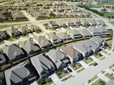 Kuzey Teksas, ABD 'de arka planda iki katlı yepyeni iki katlı evler. Hava manzaralı yeni mahalle tek çatı şehir evi ve dar sokaktaki park edilmiş arabalar.