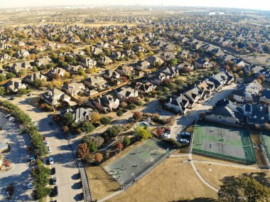 Dallas, Teksas 'ın güneyinde Cedar Hill' de iki katlı evleri ve HOA tenis kortu olan havacılık manzaralı bir mahalle. Rengarenk sonbahar yapraklarıyla yatay çizgiye yayılmış.