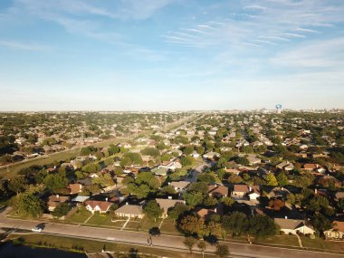 Dallas, Teksas, Amerika 'nın arka planında geniş arka bahçeleri, ahşap çitleri ve su kulesi olan tek kişilik aile evleri olan tipik yerleşim yerleri. Banliyö şefi planlı topluluklar