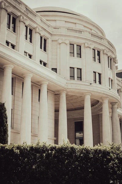 Toned photo close-up view outside of government building in Hanoi, Vietnam. White pillars columns and a dome.