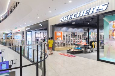 HANOI, VIETNAM-AUG 2, 2022: Asian family looking inside the Sketchers footwear and apparel store at Aeon Shopping Mall, Ha Dong. Shiny and modern Asian shopping center with international brands