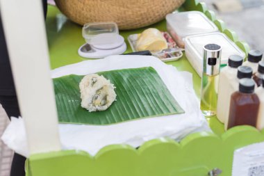 Banh Khuc or Xoi Khuc, Xoi Cuc made from Cudweed leaves, sticky rice and filled with mung beans and fatty pork at mobile vending cart in Hanoi. Local street vendor food services in Vietnam