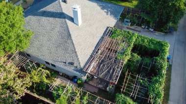 Brand new shingle roof on one story residential house with pergola, bamboo trellis compact backyard garden near Dallas, Texas, America. Homegrown organic vegetables and flower on raised beds