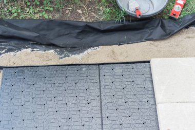 Kaldırım projesi mala, seviyeye, ot bariyerine ve kaldırım taşını kenarlı beton taban panelinde tutmak için kaldırım taşını dümdüz etmeye yönelik. Texas, ABD 'de çevre düzenlemesi yapan bir patika.