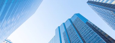 ABD 'nin Oklahoma City kentindeki gökdelenlerin panorama manzarası ve ofis binaları açık mavi gökyüzü altında. Düşük açı görünümü modern yüksek kulelerin dış görünüşü