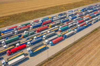 Liman terminali yakınındaki çok renkli kamyonlar yüklenmeyi ya da boşaltılmayı bekliyor. Modern lojistik merkezi. Hava görünümü.