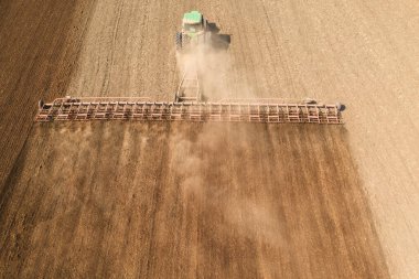 Traktör toprağı işliyor. Baharın başında nemi korumak için. Hava görünümü.