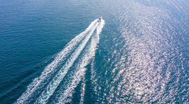 Suyun yüzeyinde yüksek hızlı bir yat manevrası yapıyor. Denizde ya da okyanusta tatiller, deniz araçlarının kiralanması. Su sporları.