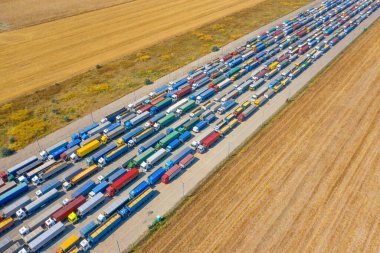 Liman terminali yakınındaki çok renkli kamyonlar yüklenmeyi ya da boşaltılmayı bekliyor. Modern lojistik merkezi. Hava görünümü.