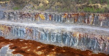 Gri taşlı büyük granit ocağı. Taş ocağının dibinde kırmızı su var. Demir Ore.