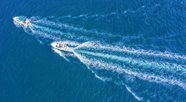 Denizde tatil. İki yüksek hızlı yat, insansız hava aracı manzaralı. Denizde yürür, deniz gemileri kiralar..