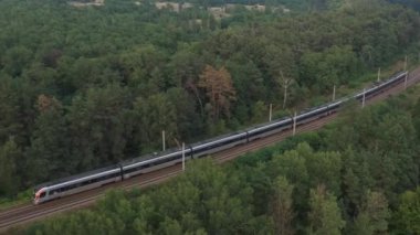 27 Kasım 2021 UKRAINE Kyiv: Modern bir elektrikli tren ormanda demiryolu ile seyahat eder.
