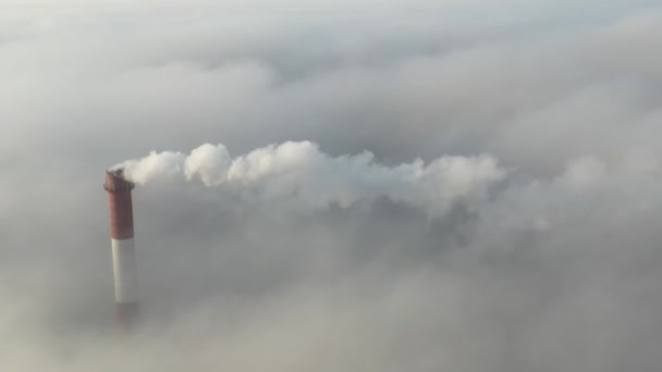 De pijp van een centrale of kolengestookte centrale hoog boven de wolken stoot schadelijke emissies uit. — Stockvideo