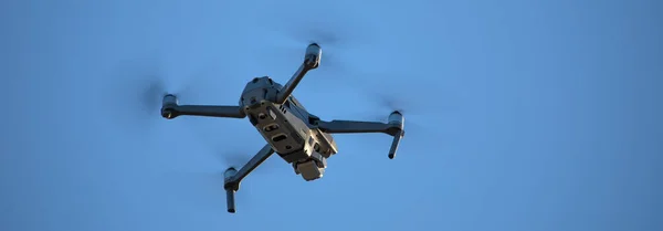Quadcopter con cámara de fotos y video colgando en el cielo. — Foto de Stock