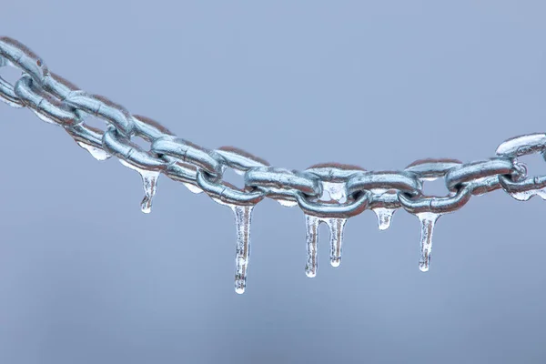 Ghiaccioli su una catena, metallo smerigliato su uno sfondo chiaro. — Foto Stock