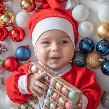 Noel Baba kostümlü, Noel ağacı süslemeli bir bebek..