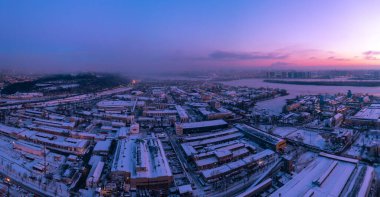 Şafakta şehrin sanayi bölgesinde. Kış manzarası, hava manzarası.