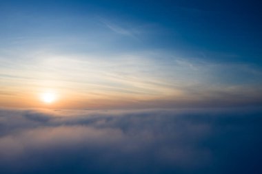 Bulutların üstünde, gün doğumu ya da gün batımı. Sisin üzerinde açık bir gökyüzü. Uçaktan bak. Kavram, seyahat, tatil. Rahatla..