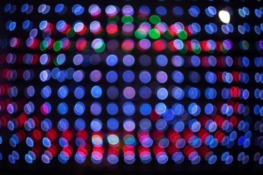 Kırmızı bokeh. Soyut şenlik arka planı. Birçok küçük ampulün parıltısı. Doku.