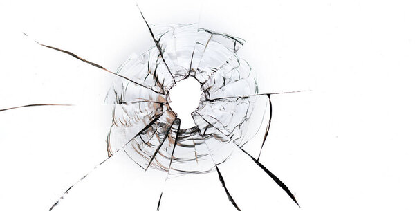 Bullet hole in the glass on a white background. Macro.