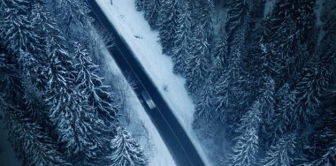 Eğri bir dağ yolunun hava manzarası Avrupa 'daki eğri bir dağ yolunun havadan görünüşü. Kış dağı manzarası. Karla kaplı ağaçlar ve dağ yamaçları. İnsansız hava aracı görüntüsü..