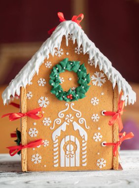 Beyaz ahşap masa üzerinde zencefilli kek evi seçici bir odak noktası. Yeni yıl hediyesi..