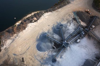 Granit fabrikası. Göl ve granit ocağının yanında büyük granit yığınları var..