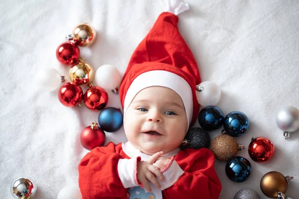 Noel Baba kostümlü, Noel ağacı süslemeli bir bebek..