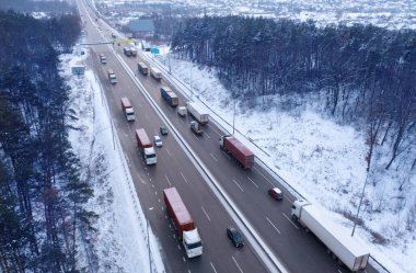Otobanda bir sürü kamyon var. Kış endüstriyel manzarası. Drone görünümü.