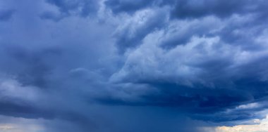 Stormy sky before rain. Abstract natural background. Heavy dark rain clouds on a light sky background.