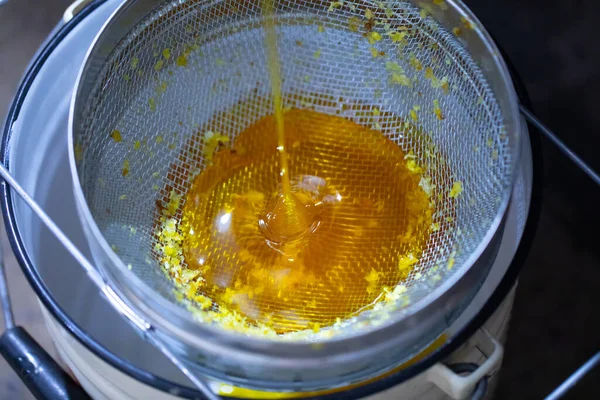 Filtering honey from a honey bee, through a sieve of small and large fractions.