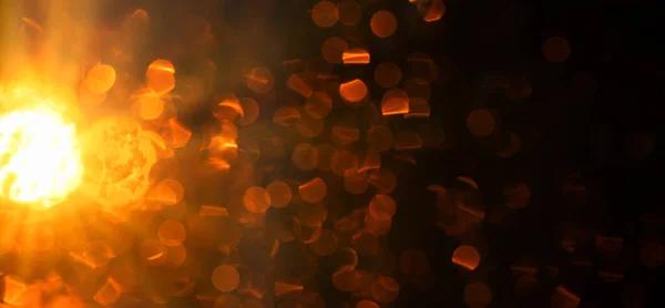 Bright golden bokeh or glow on a dark background.