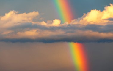 Rainbow on the background of storm clouds. Abstract natural background. The end of the rain, the improvement of the weather. concept