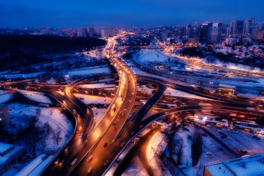 Multi-level traffic interchange night winter drone view. Industrial landscape.
