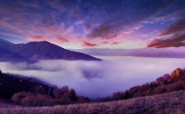Morning in the mountains. A wonderful autumn landscape. Blue morning sky, sun rays and morning fog. Bright natural background.