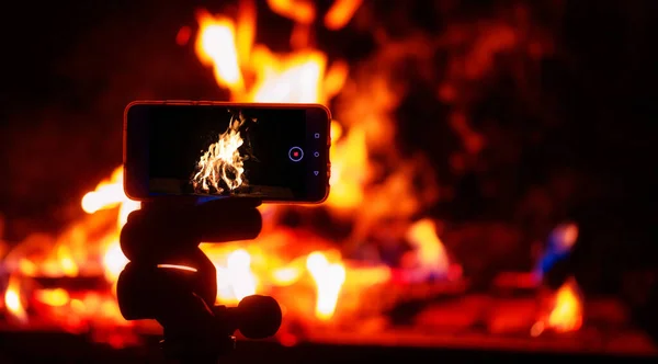 Shooting on the phone. A smartphone on a tripod shoots fire.