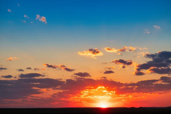 Orange sky after sunset or before dawn. A wonderful natural landscape. Pink clouds and blue starry sky.