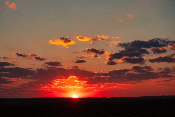 Orange sky after sunset or before dawn. A wonderful natural landscape. Pink clouds and blue starry sky.